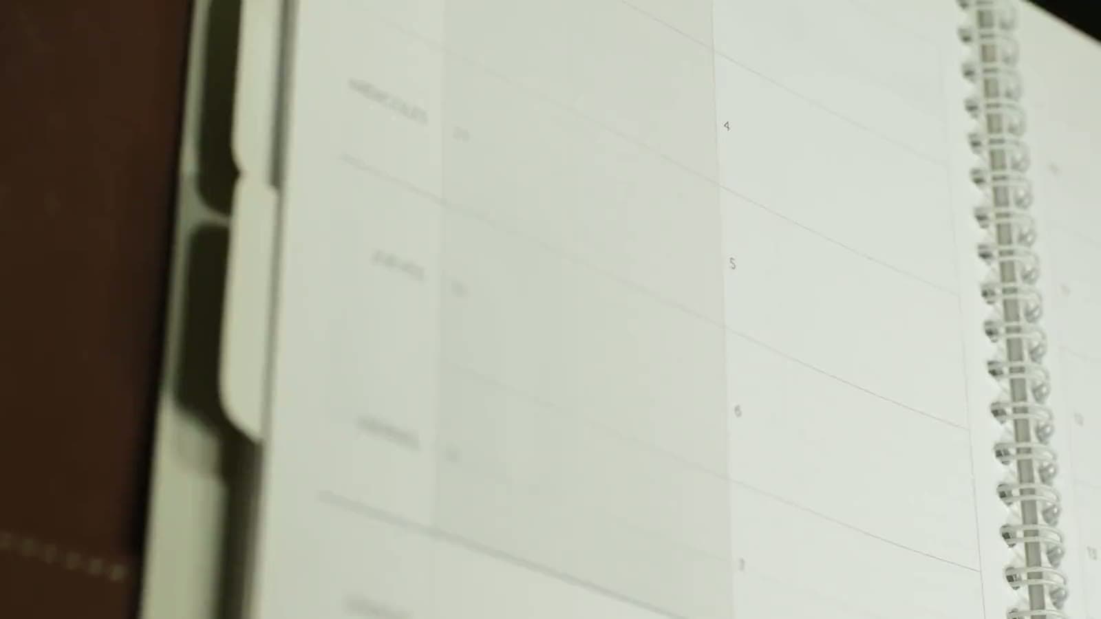 Una mano escribe “Save the date” en una agenda