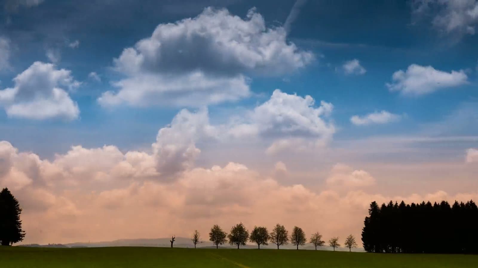 Clouds drifting across a big sky over open country