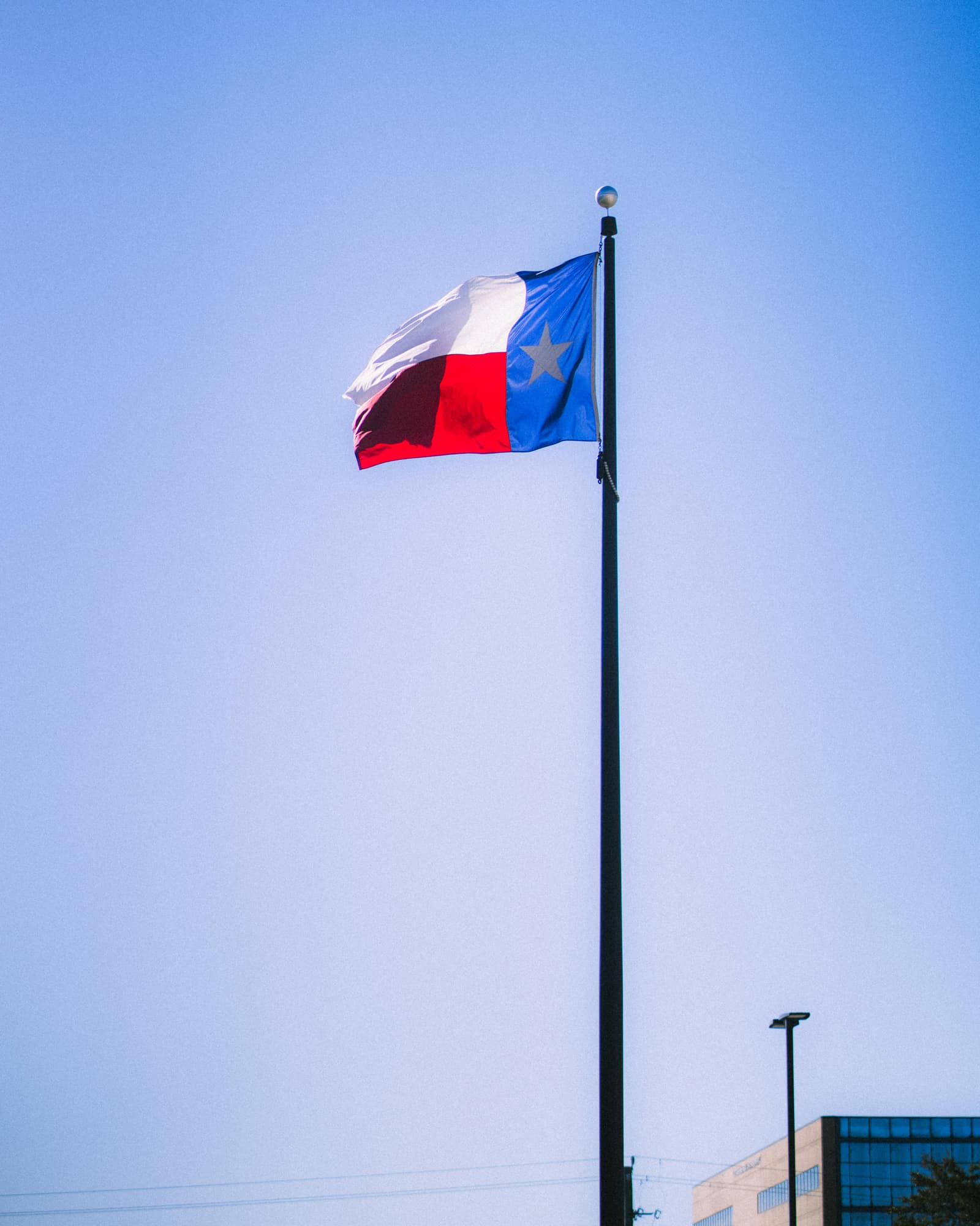 Una bandera de Texas ondeando en un asta contra un cielo despejado